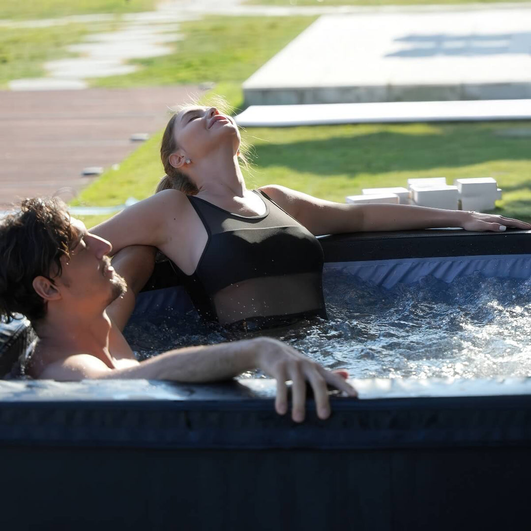 A couple relaxing in bubbling water hot tub, woman in focus.